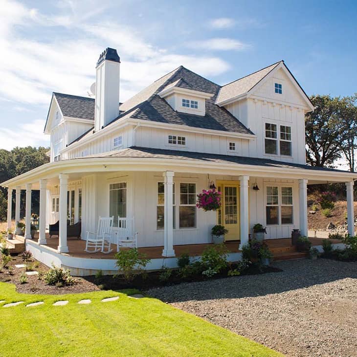 Farmhouse exterior with wraparound porch and yellow front door