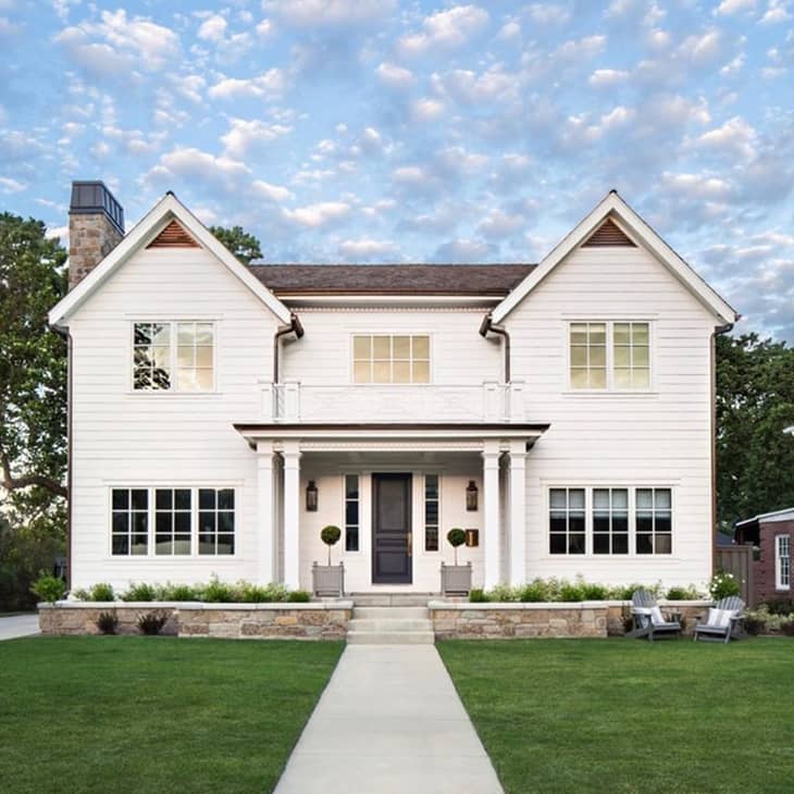 Traditional white farmhouse exterior with black front door