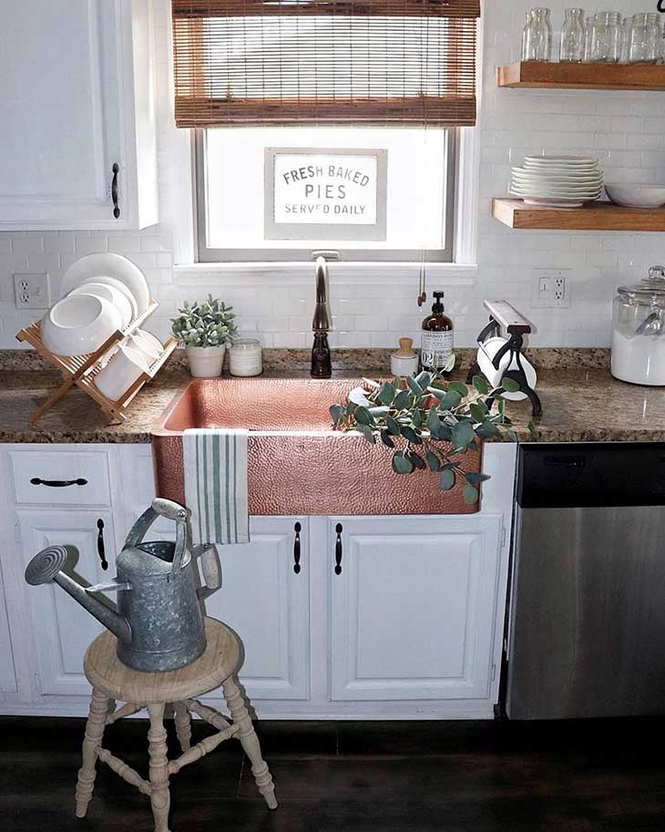 copper kitchen sink with white subway tile and white kitchen cabinets