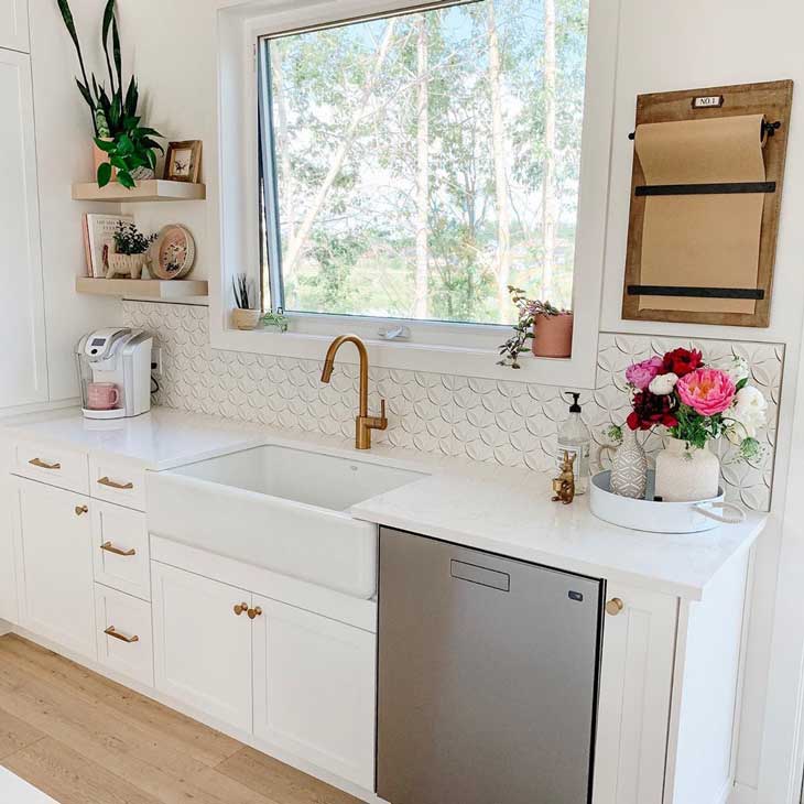 farmhouse kitchen sink with cooper faucet on white kitchen with open shelving and pattern tile