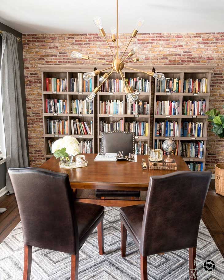 masculine home office with bookshelf background and brick wall, industrial home office