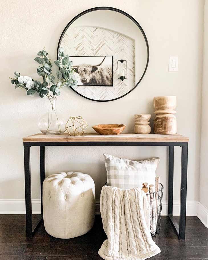 Entryway table with metal legs, neutral decor and round mirror