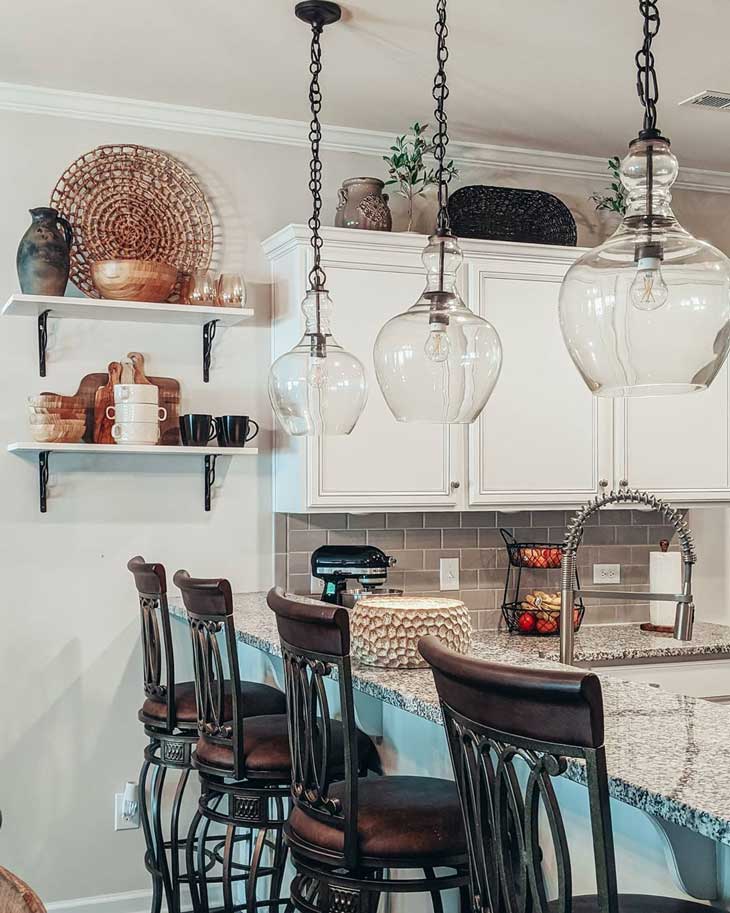 glass pendant lighting over kitchen bar with open shelving