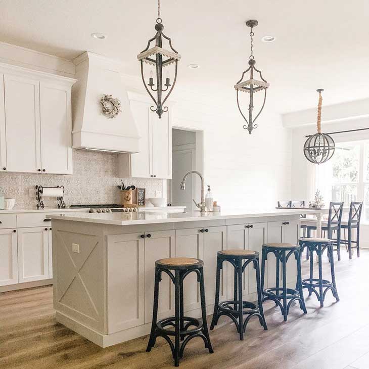 rustic pendant lights over big kitchen island with black barstools