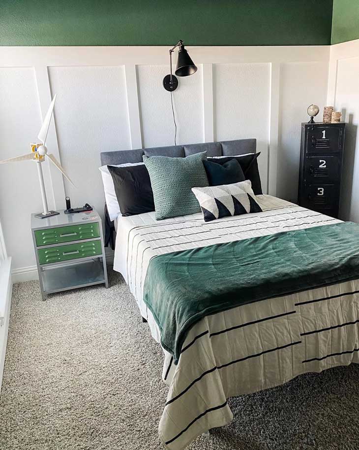 Green kids room with green walls and white wood paneling, white and green bedding with metal file cabinet