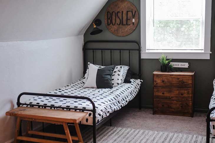 Attic kids room with black metal bed 