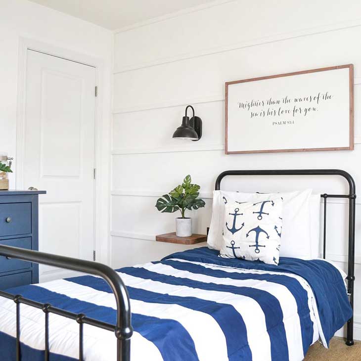 Nautical kids room with black metal bed and blue bedding