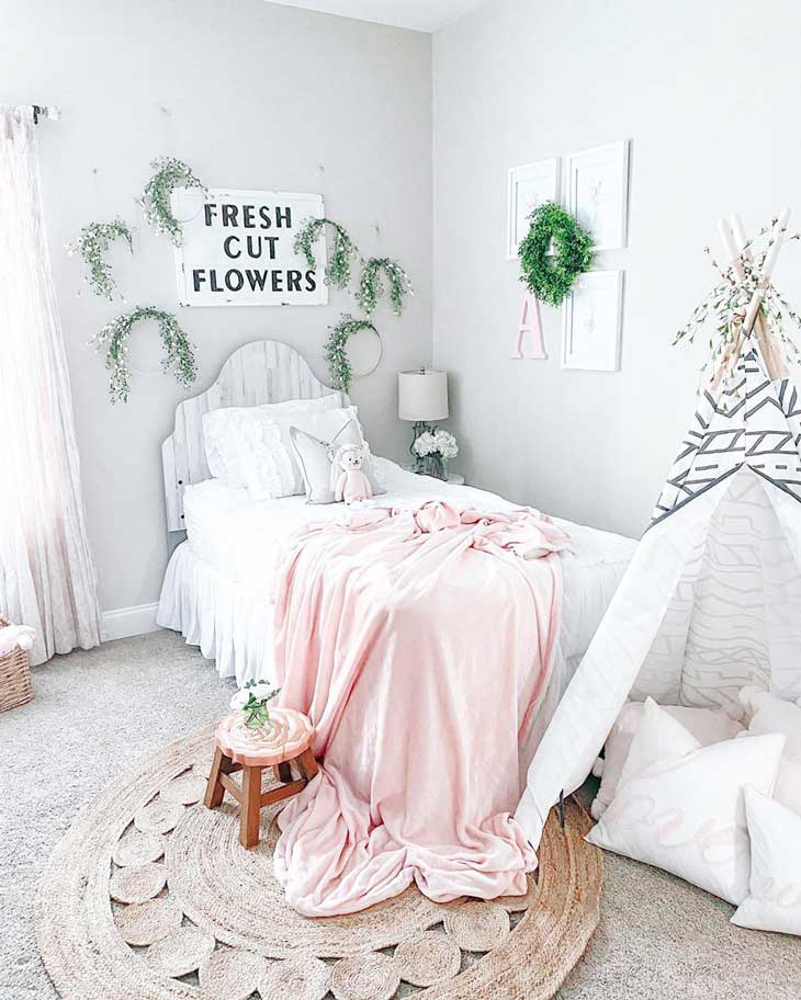 Boho kids bedroom with greenery and pink and grey decor with jute rug