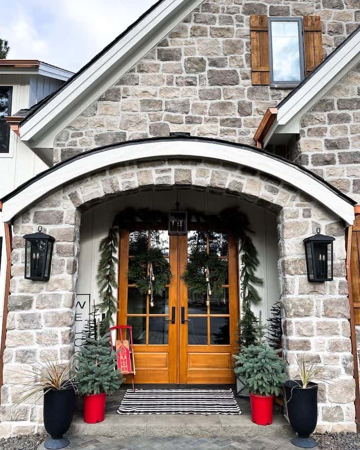 Modern farmhouse Christmas porch with double french door decorated with garland and two wreaths