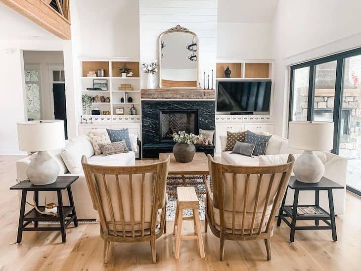 Black and ,white farmhouse living room with shiplap fireplace and white couches facing each other 