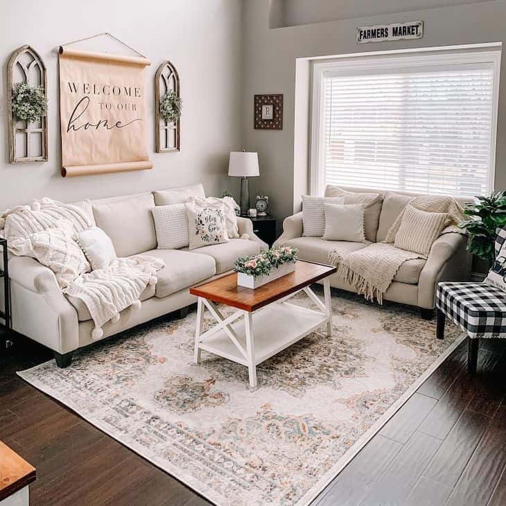 Small farmhouse living room with nude couches and dark wood floors