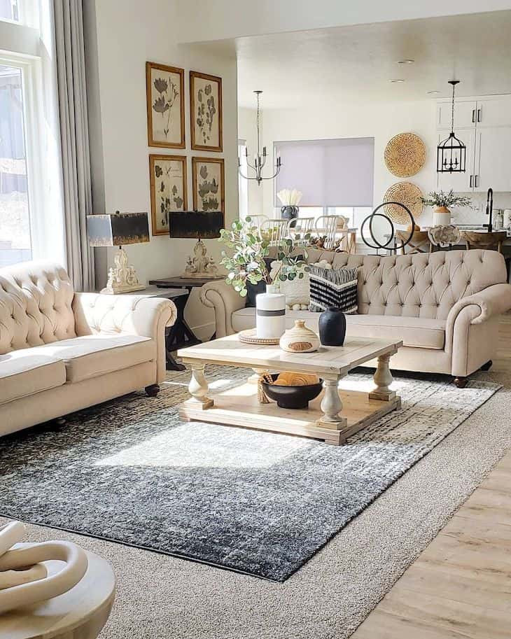 Classic farmhouse living room in neutral tones with chesterfield sofas and wood square coffee table