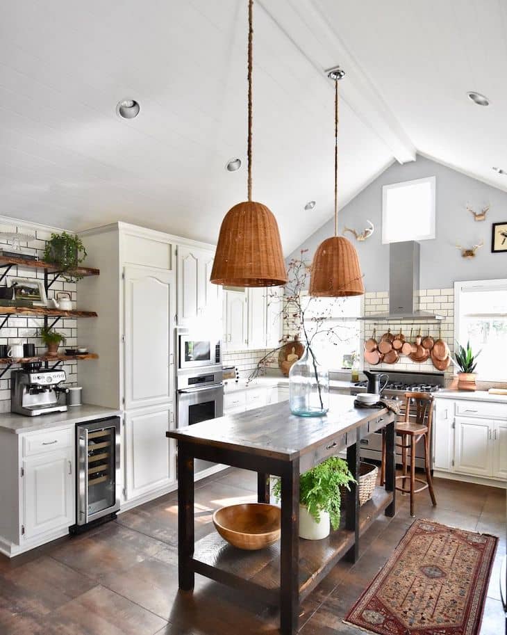 Open shelf kitchen in the coffee/ bar area with big antique table as a kitchen island.