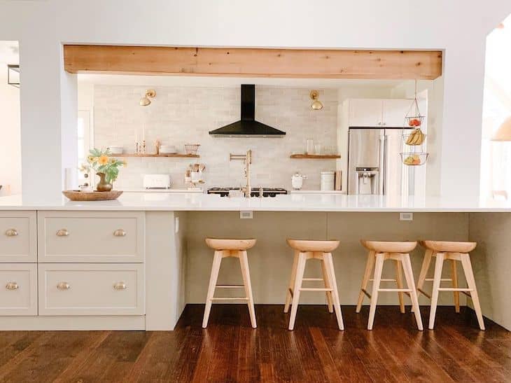 A wall of shelves in a kitchen with big island