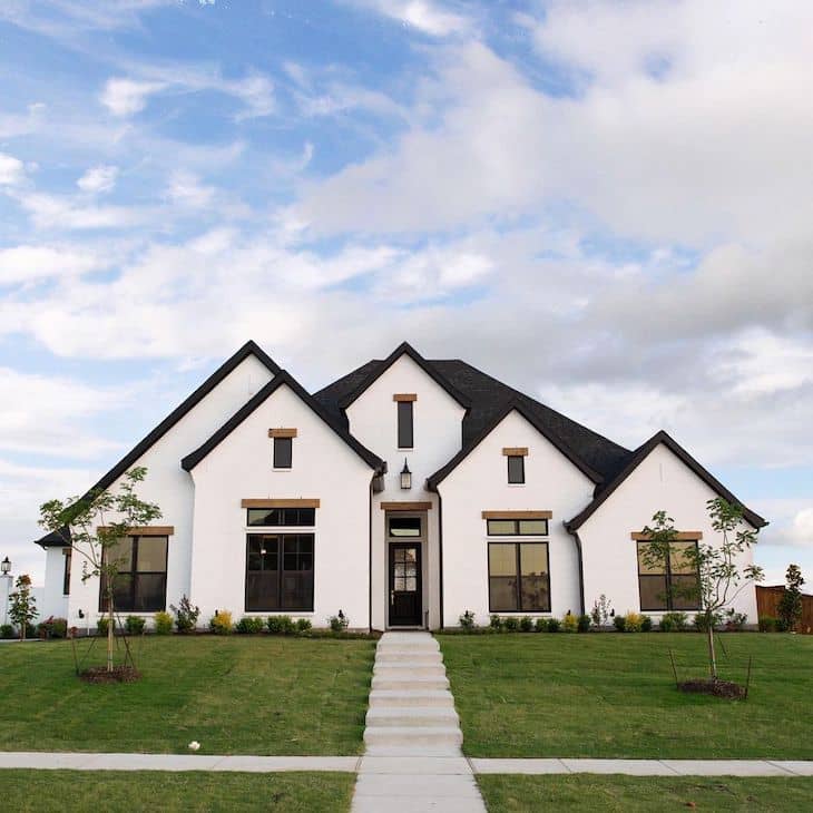 Blank and white modern farmhouse exterior with white brick, black door and black window trim