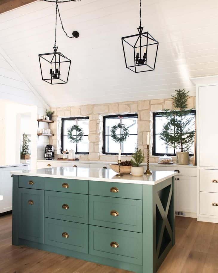 White kitchen with green island and natural stone backsplash