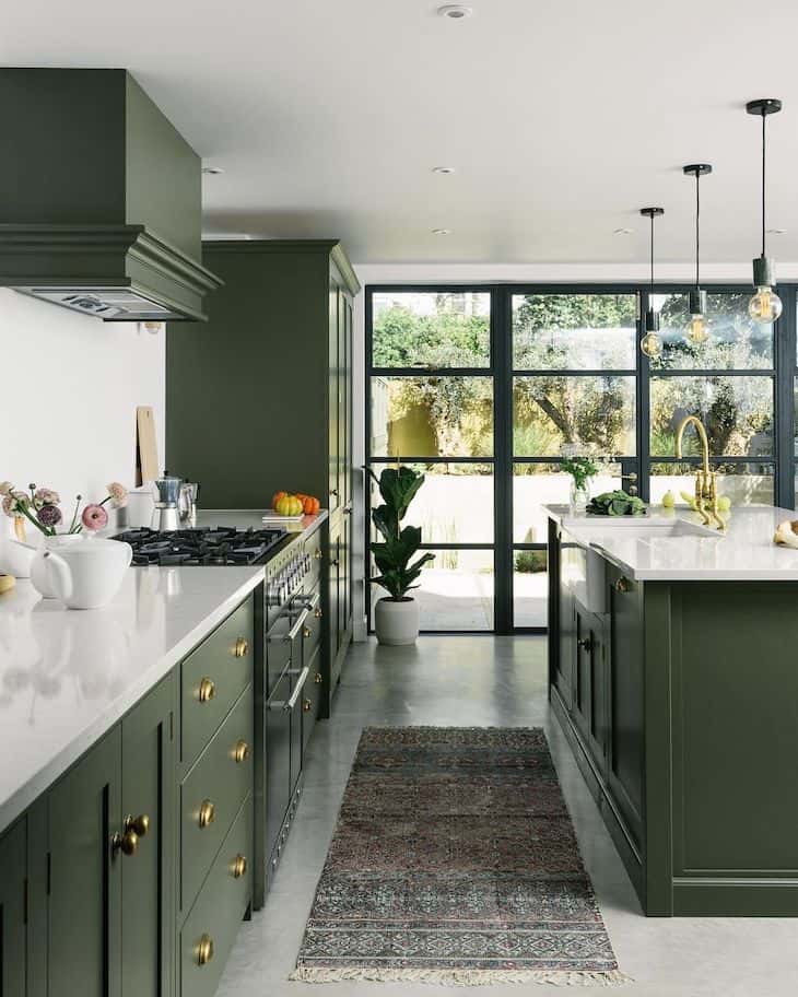 Olive green kitchen with polished concrete floor and bohemian rug