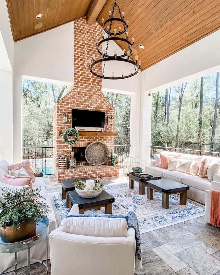 Covered outdoor patio with a brick fireplace 