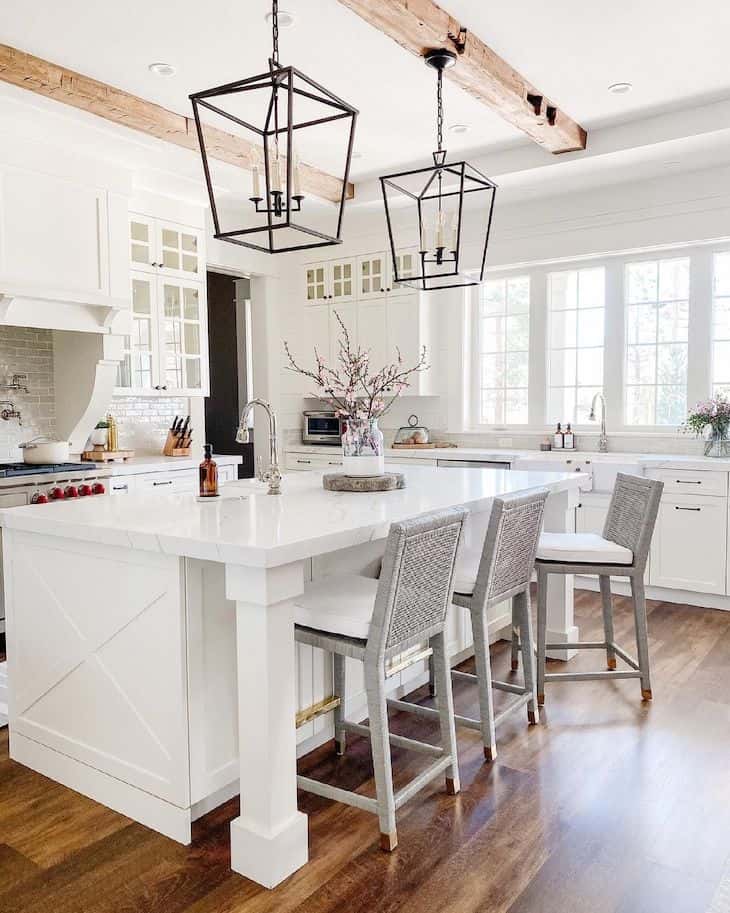 White kitchen island with three bar stools