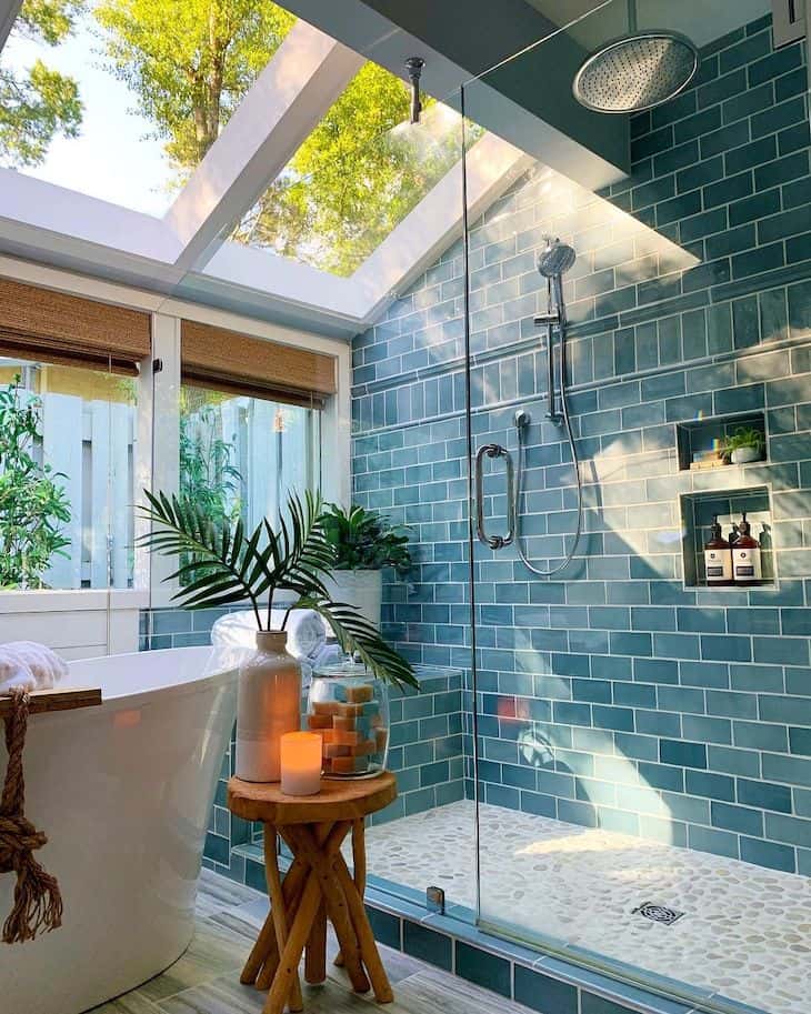 Turquoise shower tile and pebble shower floor tile in a coastal bathroom