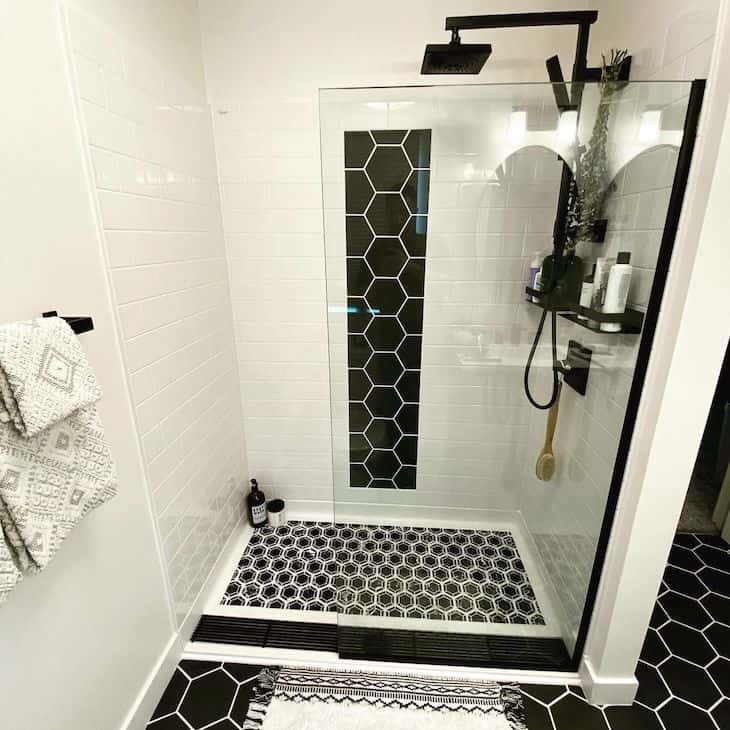 White shower tile in subway pattern with black floor tile