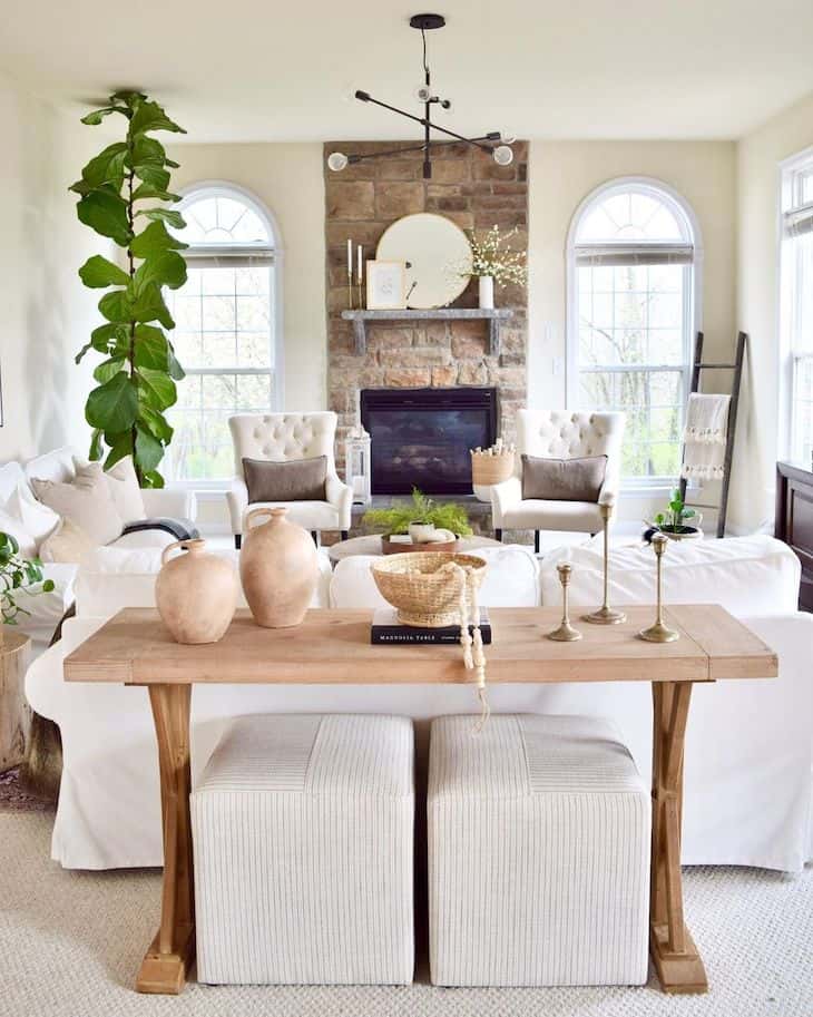 Neutral wood sofa table with poufs underneath 