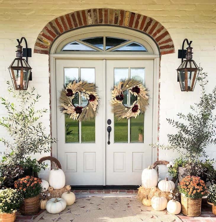 Double front door fall decor with two wreaths and pumpkins