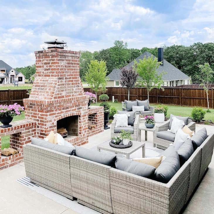 Freestanding brick outdoor fireplace with patio furniture