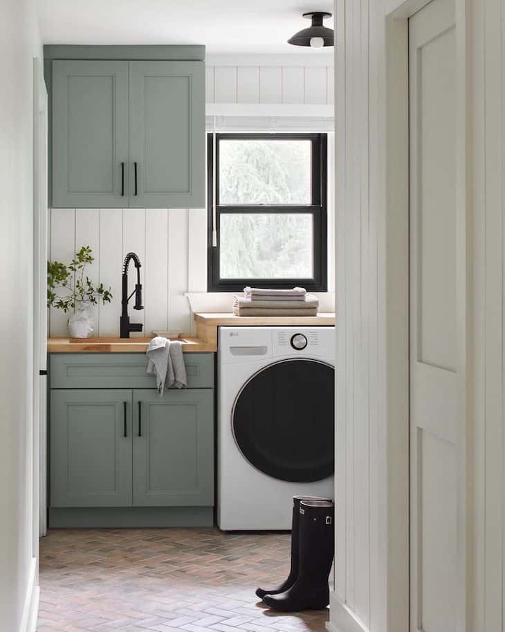 Small laundry room with green cabinets