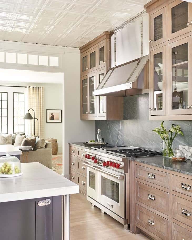 wood kitchen cabinets and black marble backsplash