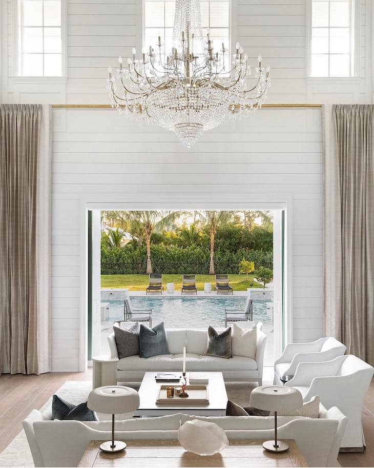 Elegant White Living Room with Grand Chandelier and Outdoor Views