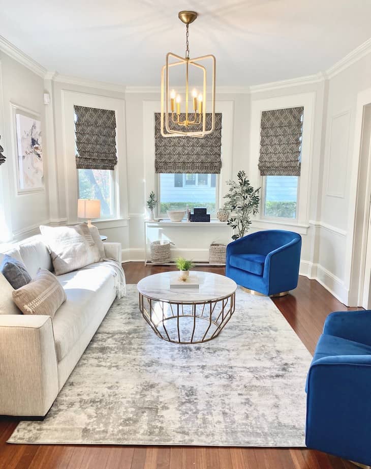 White Living Room with Bold Blue Chairs and Gold Accents